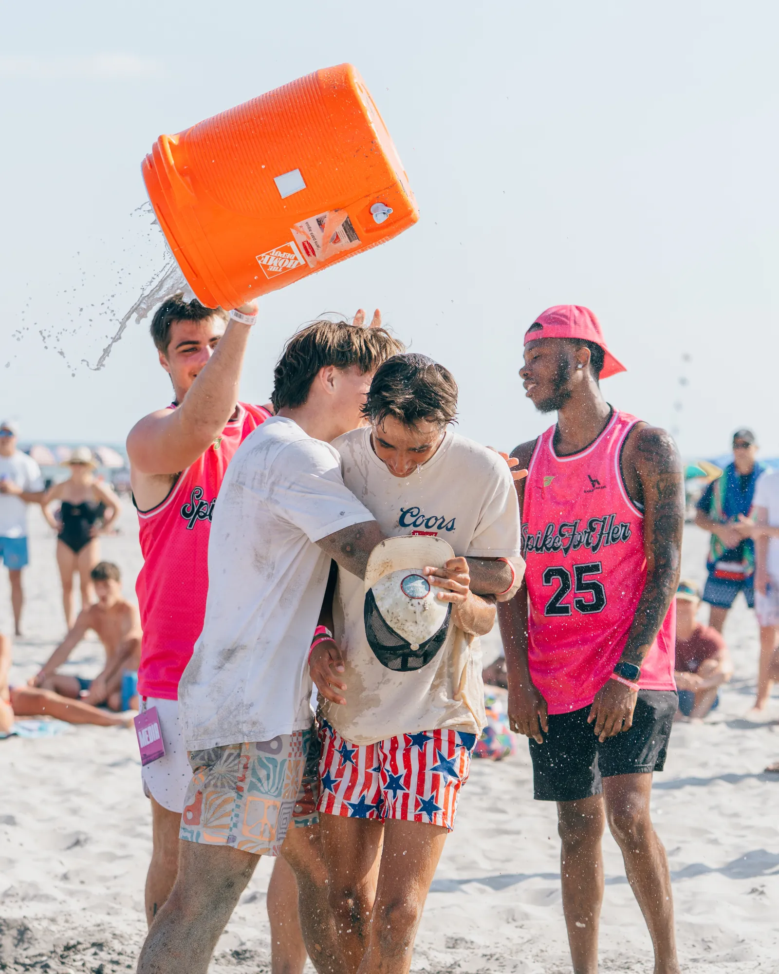 Players dumping an orange cooler of ice water over a winning teammate